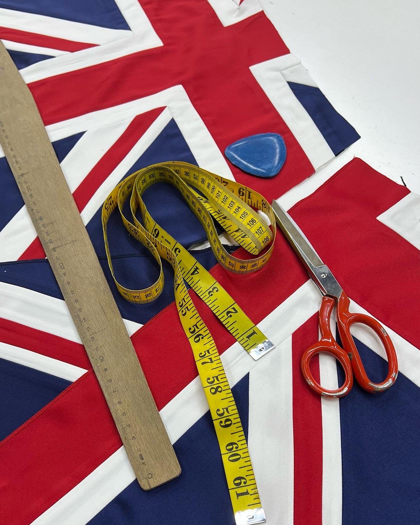 Tape measure, chalk, ruler and scissors on fabric