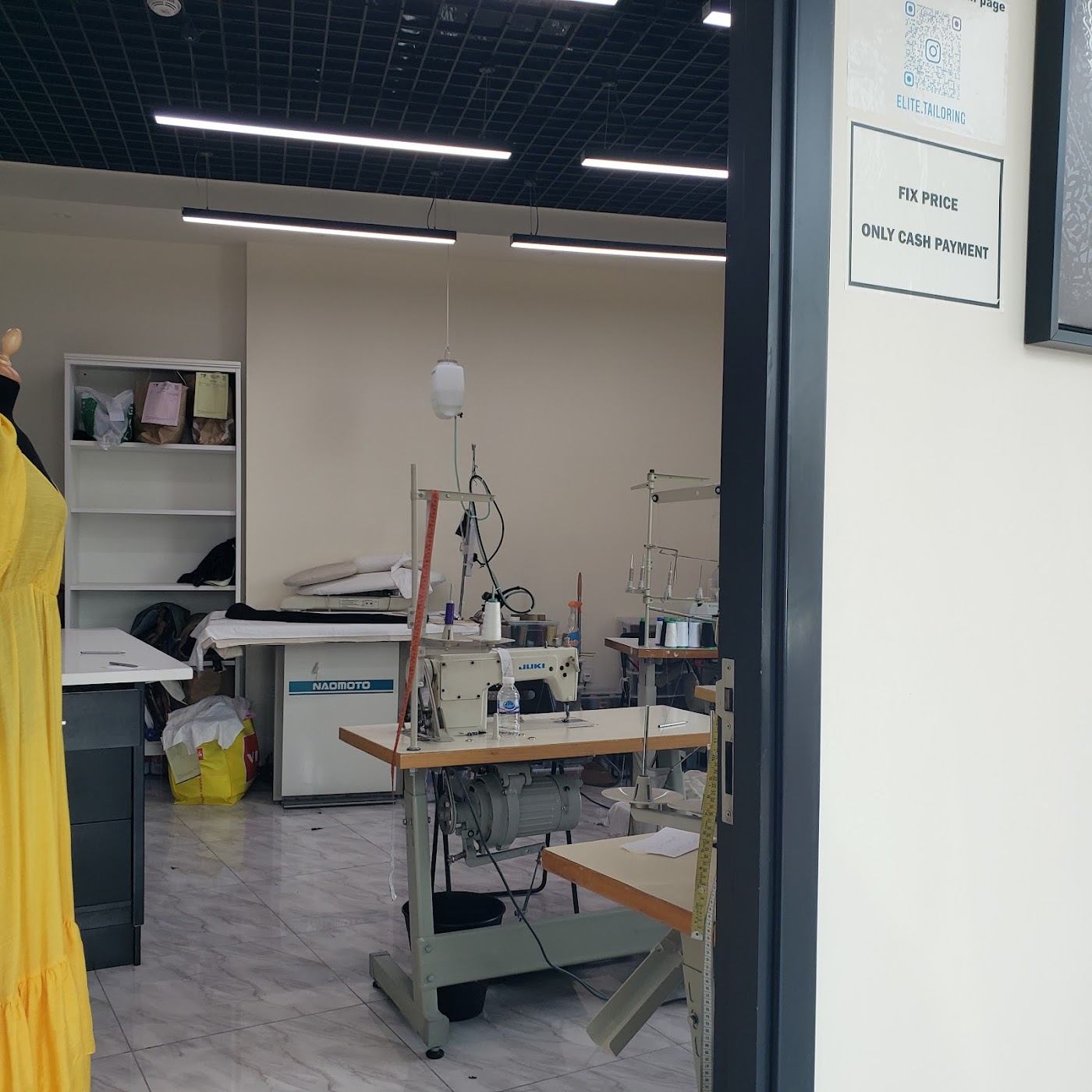 The sewing workroom with machines and pressing table